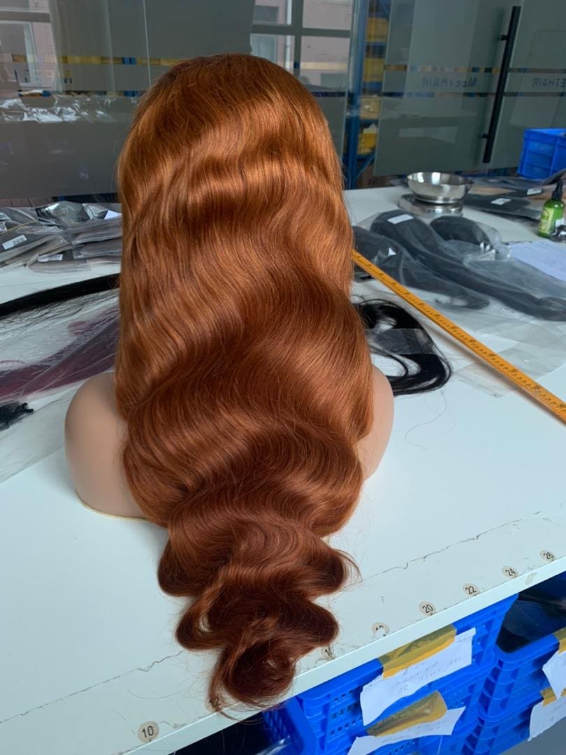 A woman with long red hair sitting at a table.