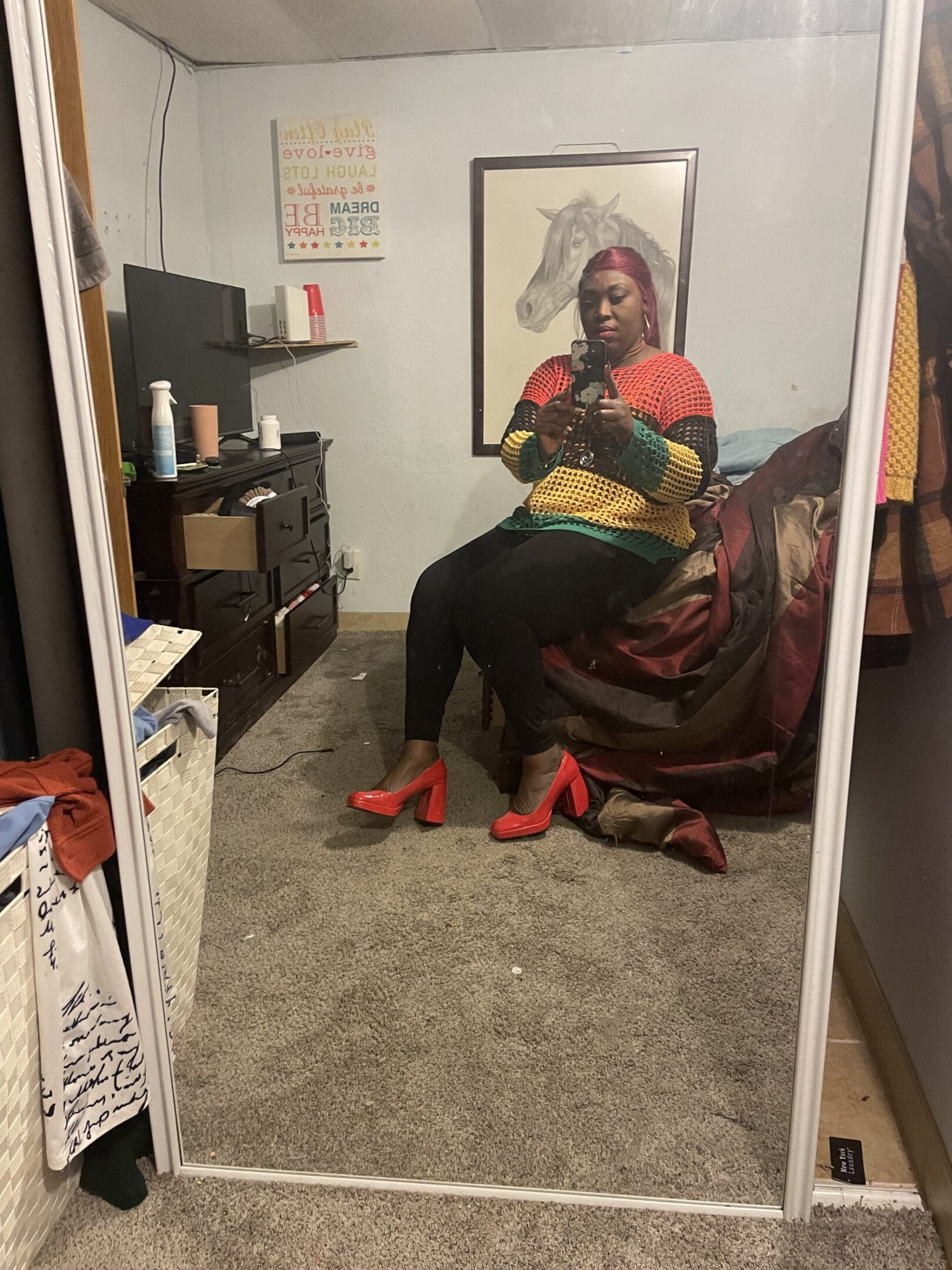 A woman sitting on the floor in front of a mirror.