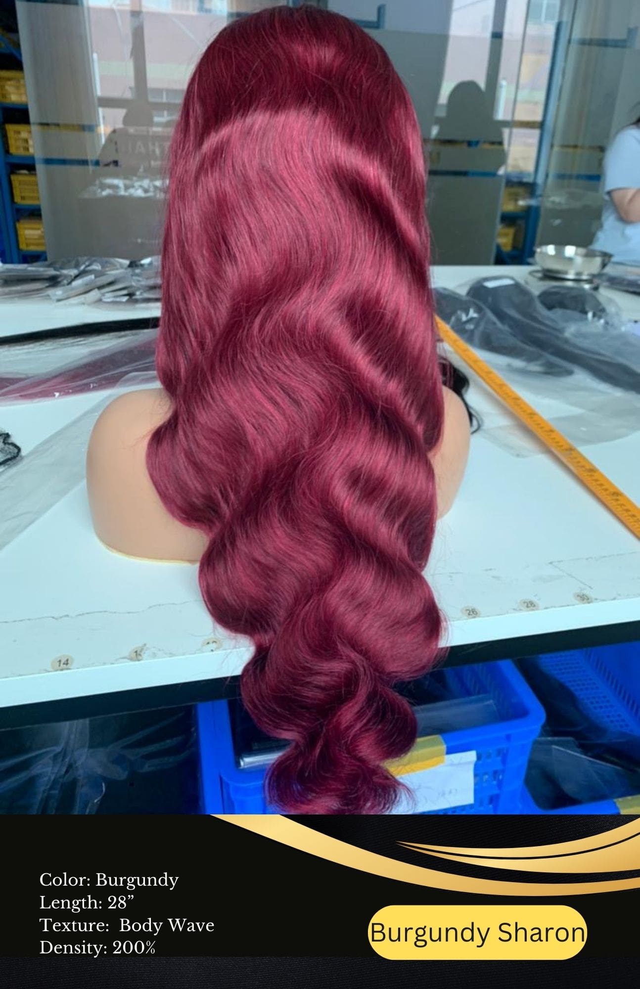 A woman with long red hair sitting in front of a blue table.